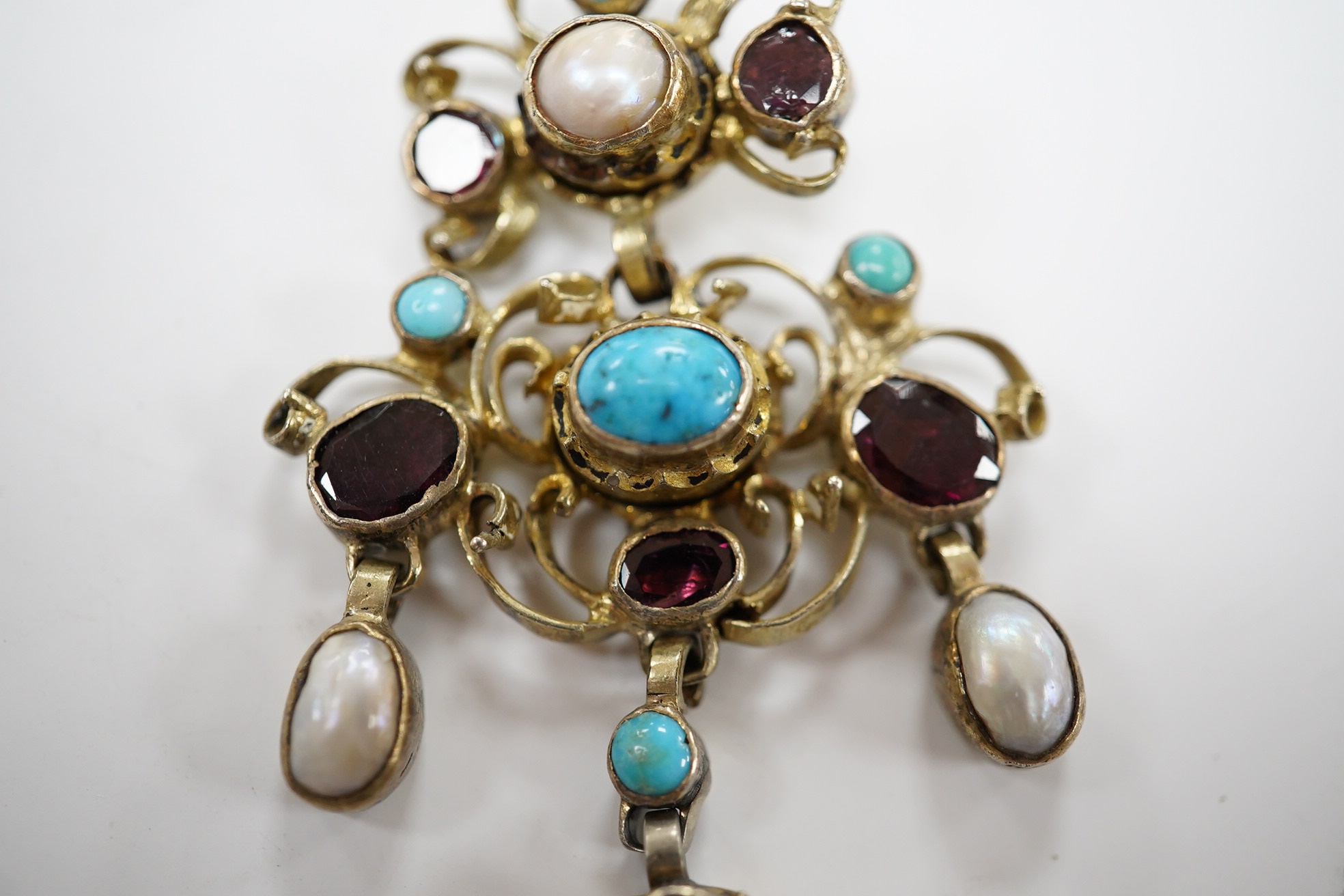 A 19th century Austro-Hungarian? gilt white metal, turquoise, garnet and split pearl set drop pendant, 53mm. Condition - poor to fair